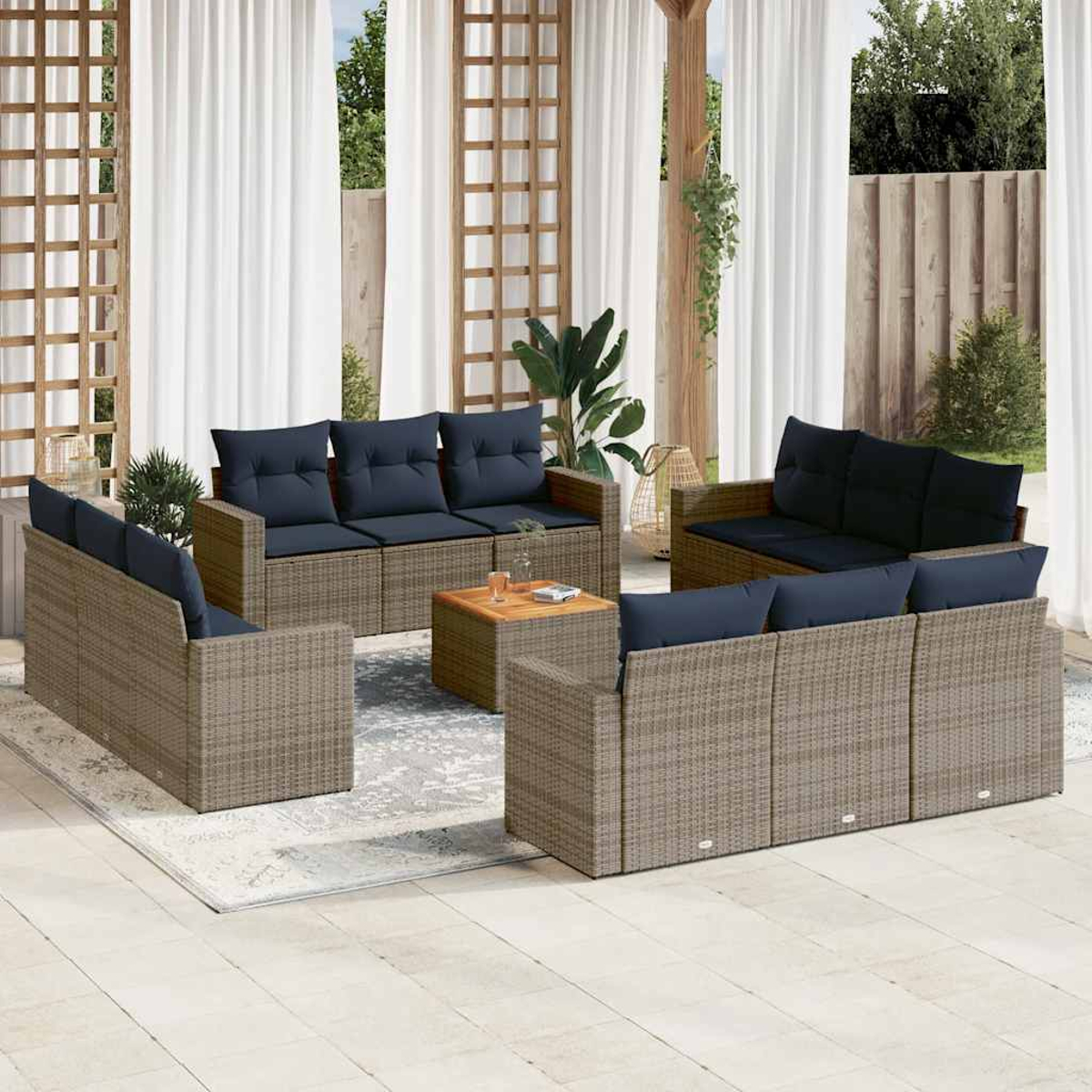 Rattanset für den Außenbereich mit blauen Kissen. Enthält Sofas, Stühle und einen kleinen Tisch.