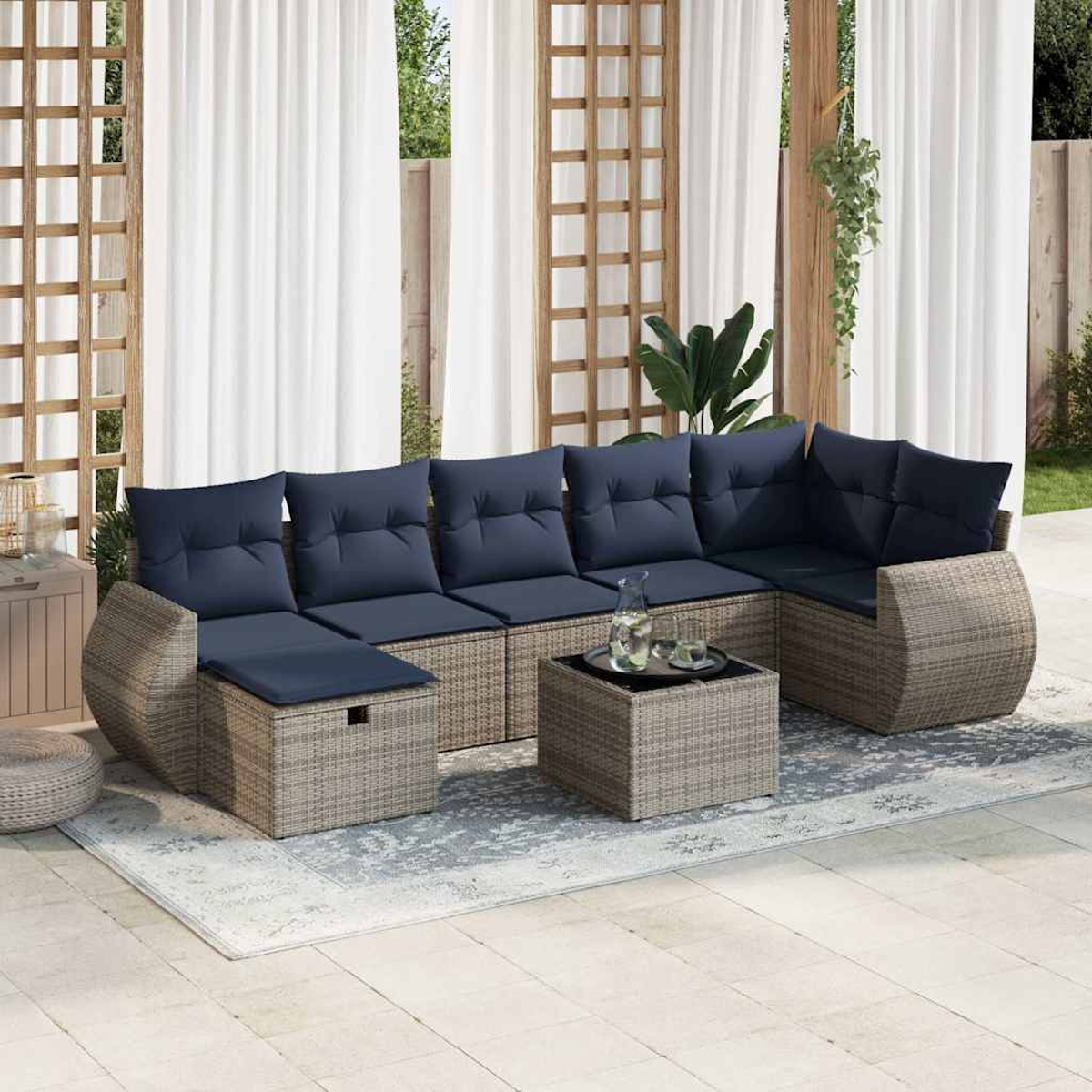Un sofá seccional de mimbre para exteriores con cojines azul oscuro y una mesa.