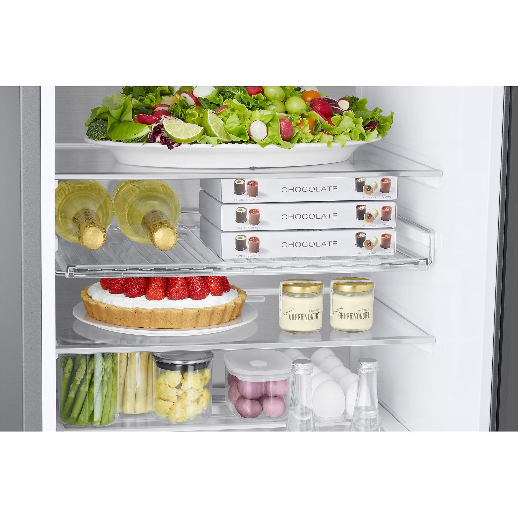 Kühlschrankregale zeigen einen Salat, Schokoladenschachteln, eine Erdbeertarte, Joghurt, Spargel und Mineralwasser.