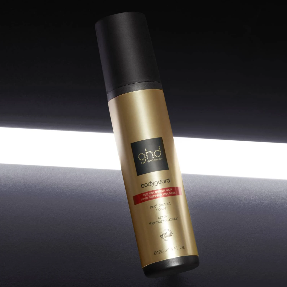 Una bomboletta spray oro e nera su una superficie scura. La bomboletta ha un tappo nero e testo bianco.