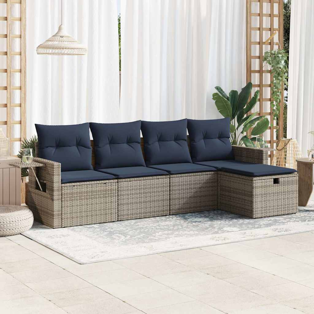Ein helles Ecksofa aus Korbgeflecht mit dunkelblauen Kissen. Ein kleiner Beistelltisch und ein Teppich ergänzen die Szene.
