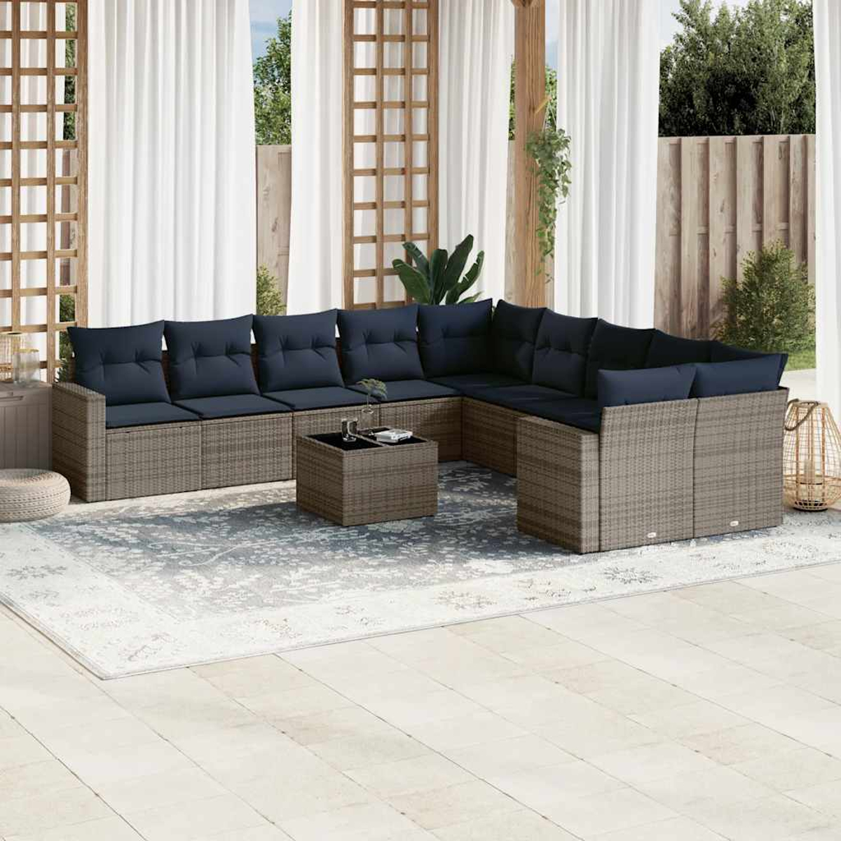 Ein moderner Sitzbereich im Freien mit L-förmigem Sofa, Couchtisch und gemustertem Teppich.
