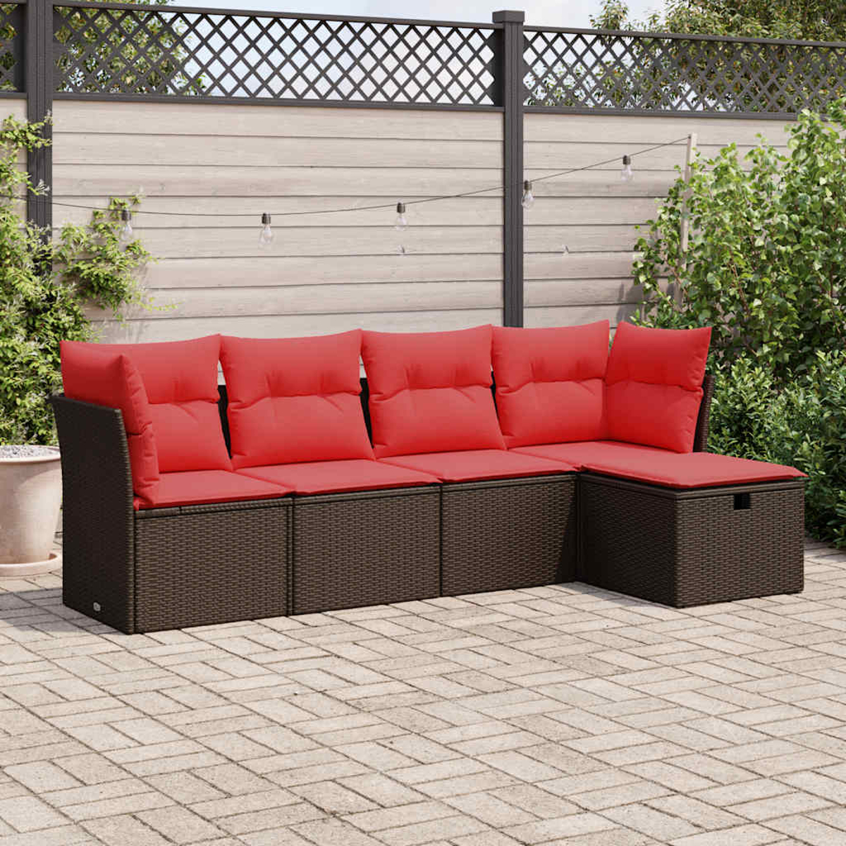 Ein L-förmiges Outdoor-Sofa mit roten Kissen, dunkelbraunem Korbgeflecht auf einer Ziegelterrasse.