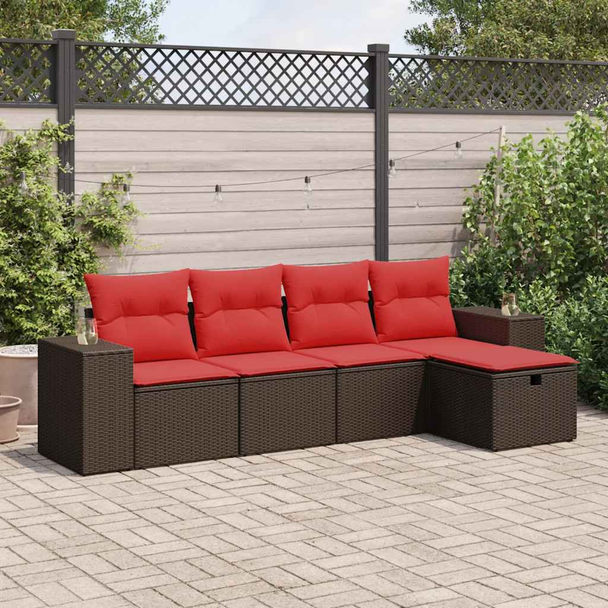 Ein braunes Ecksofa für den Außenbereich mit roten Kissen. Das Sofa ist aus Korbgeflecht.