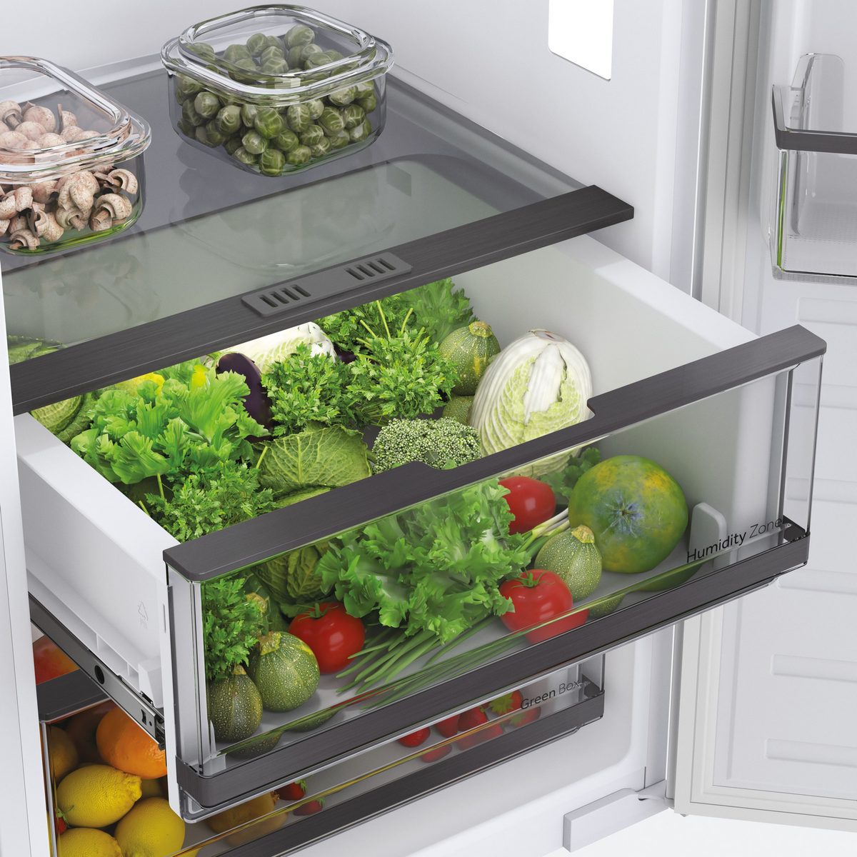 Un cajón de nevera lleno de verduras como lechuga, calabacín, tomates y brócoli, todo fresco y colorido.