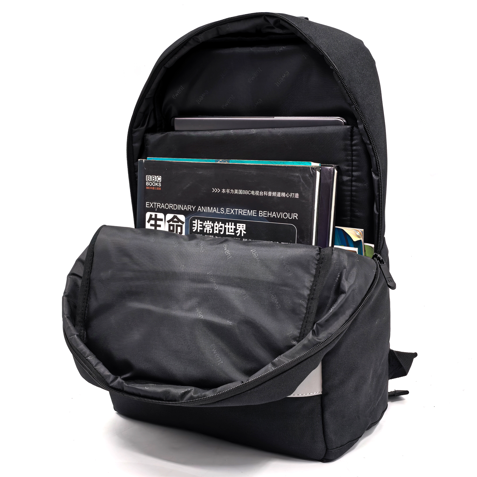 Zaino nero aperto con libri e un tablet all'interno. Sfondo bianco.