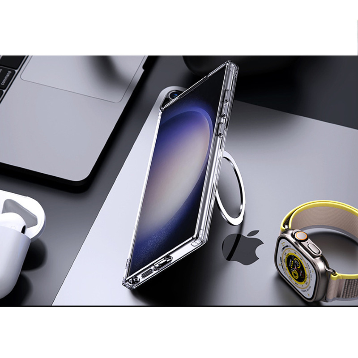 Transparente Handyhülle mit Telefon, Ringhalter. Apple Watch und Airpods auf dem Tisch. Grauer Hintergrund.