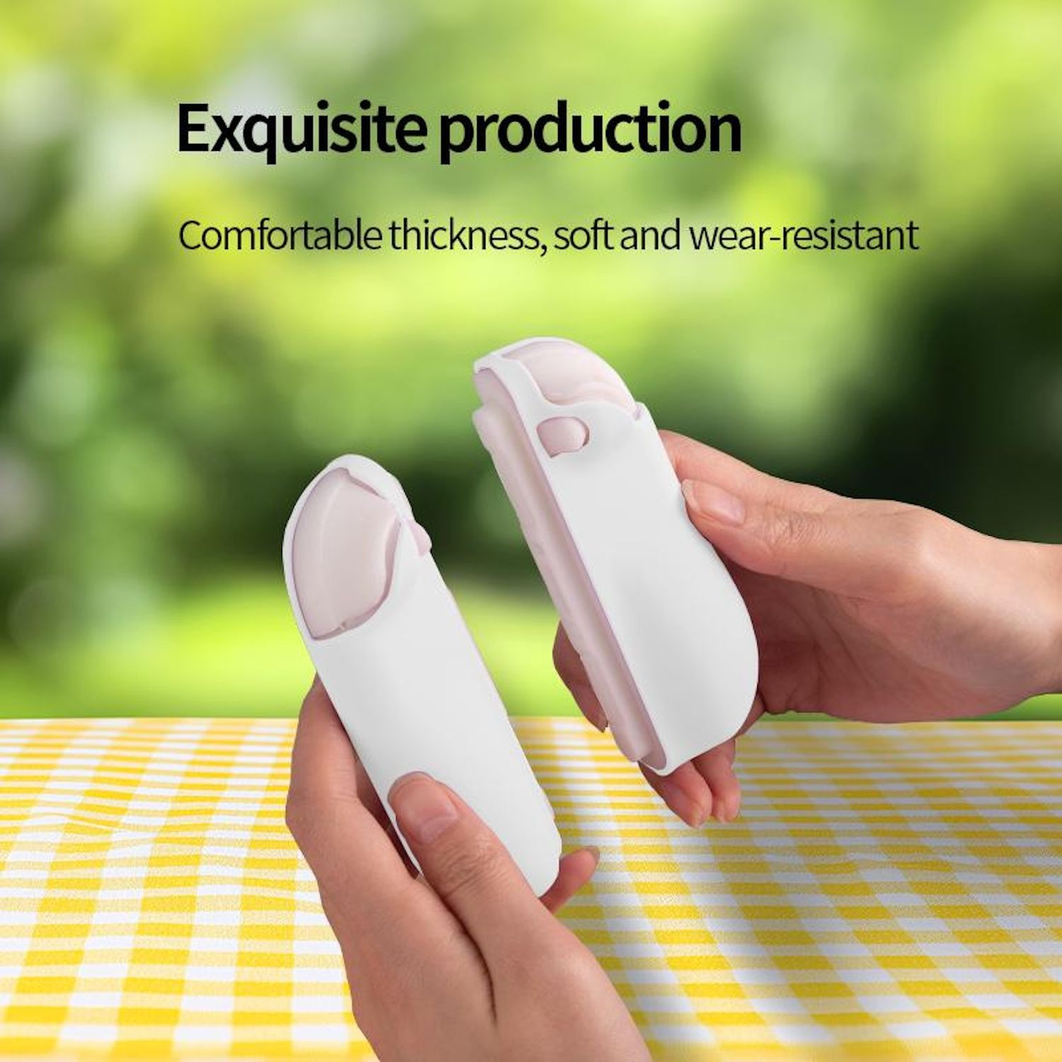 Zwei getrennte weiße und rosa Gamecontroller in zwei Händen gehalten. Der Hintergrund ist eine verschwommene Außenszene.