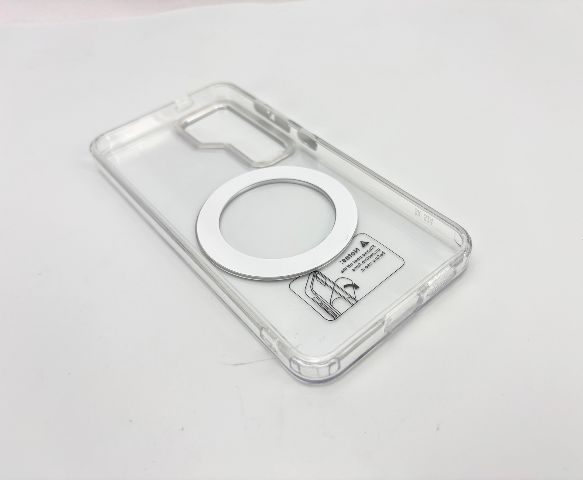 Transparente Handyhülle mit Magnetring, Anweisungsetikett auf der Rückseite, auf weißer Oberfläche.
