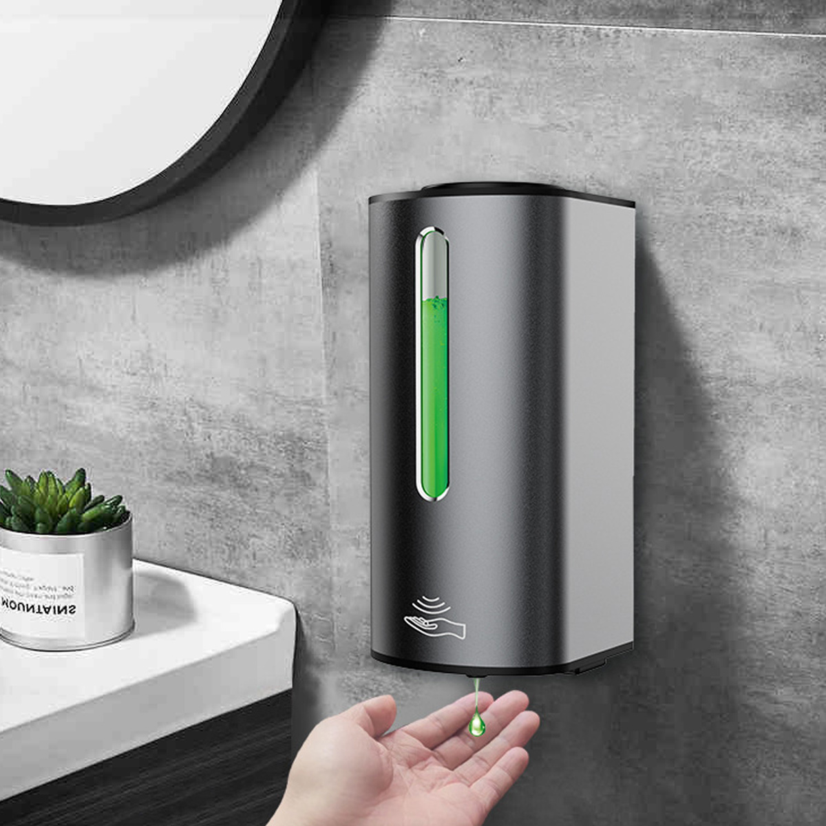 Silberner und grauer automatischer Seifenspender an der Wand mit grüner Flüssigkeit. Eine Hand darunter.