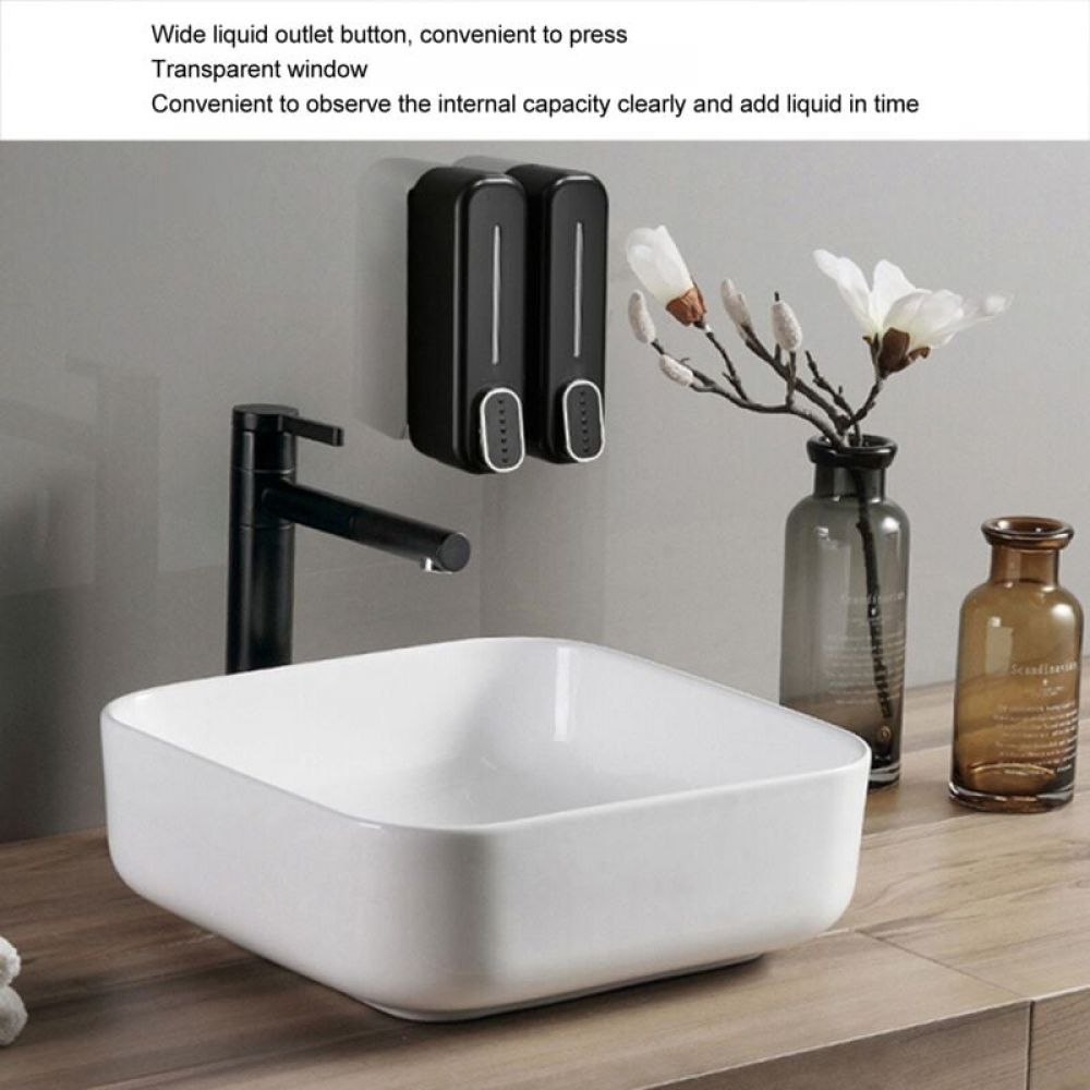 Ein weißes Waschbecken mit einem schwarzen Wasserhahn. Zwei schwarze Seifenspender sind an der Wand befestigt.