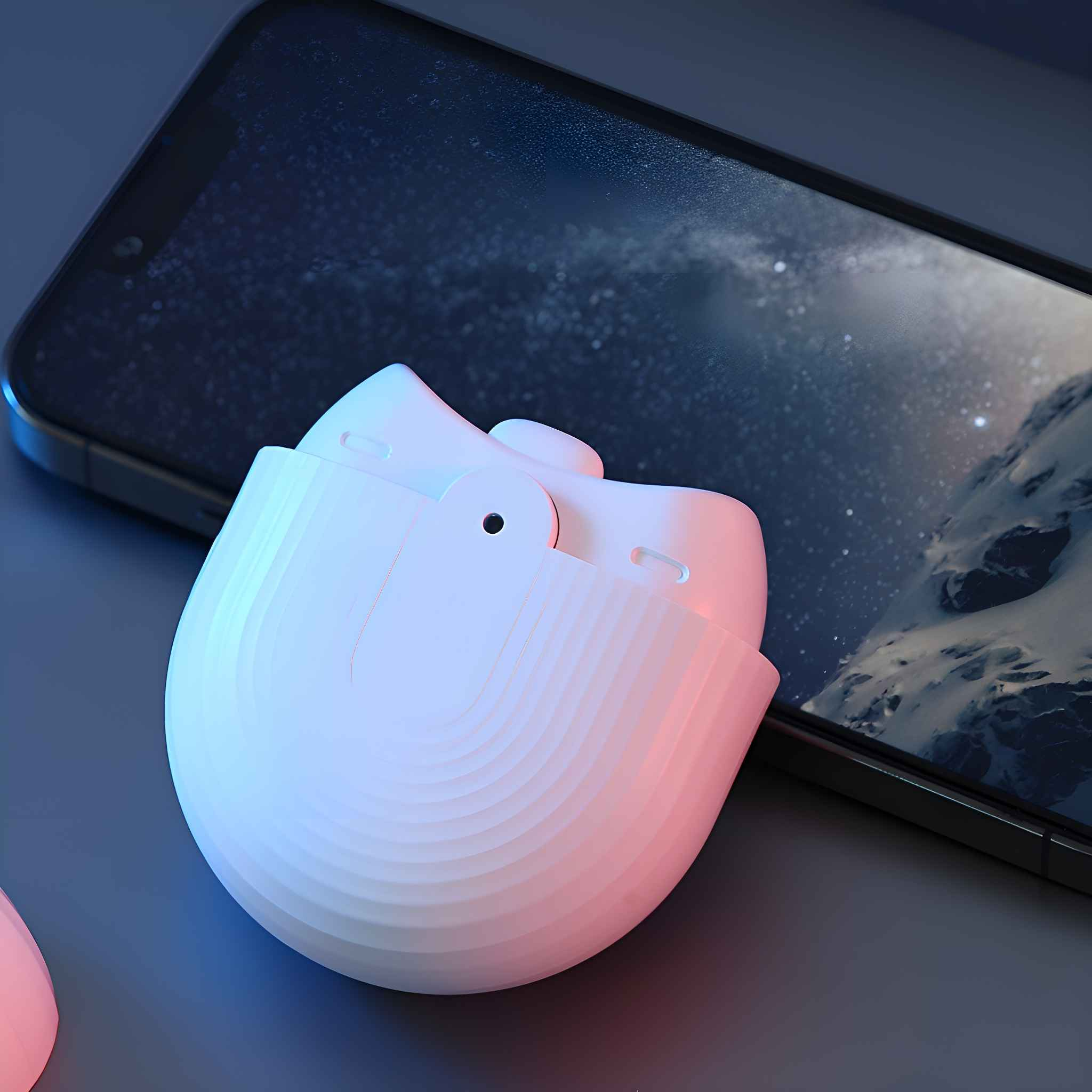 Weißes, eiförmiges Gerät, das auf einer dunklen Oberfläche geladen wird, mit einem Telefon dahinter. Es hat einen Knopf.