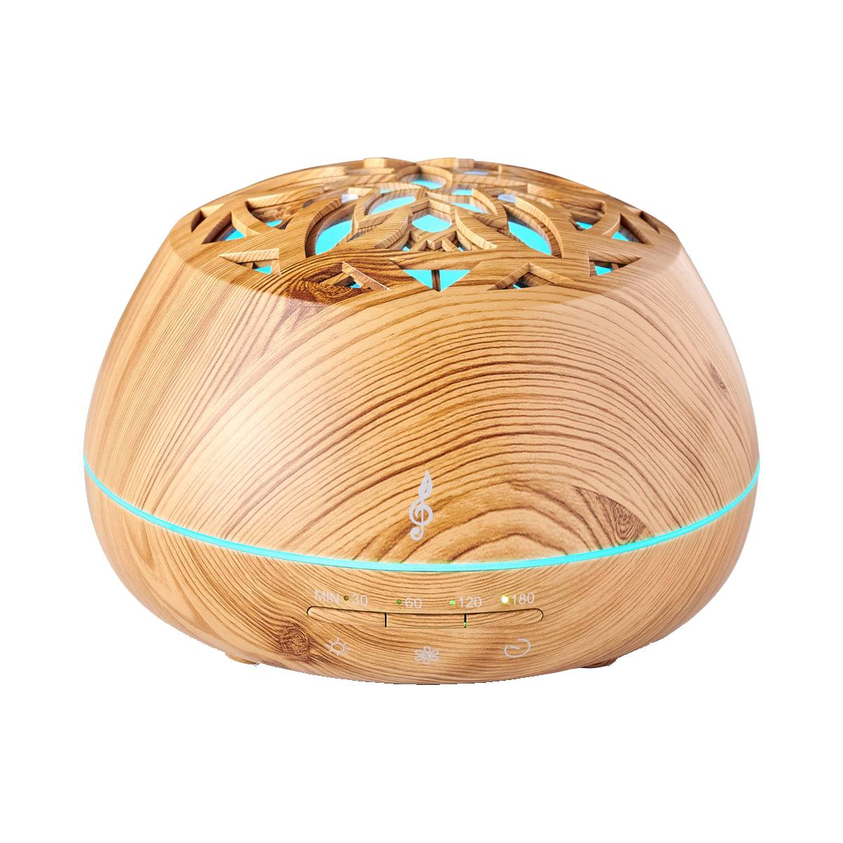 Un diffusore di oli essenziali dall'aspetto di legno con un motivo floreale sulla parte superiore e luce blu emessa.