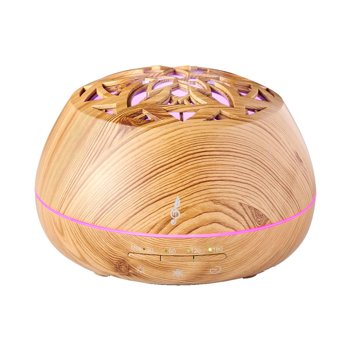 Diffusore di aromi in legno con un motivo floreale sulla parte superiore, con luce rosa che brilla attraverso.
