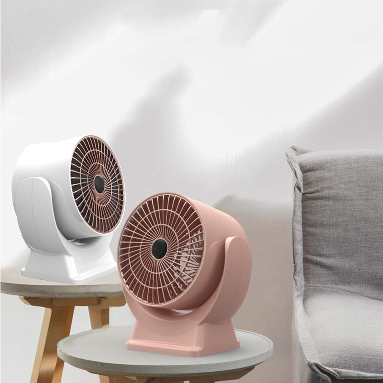 Zwei kleine Heizlüfter auf Tischen. Einer ist weiß, der andere rosa. Sie haben ein Lüfterdesign.