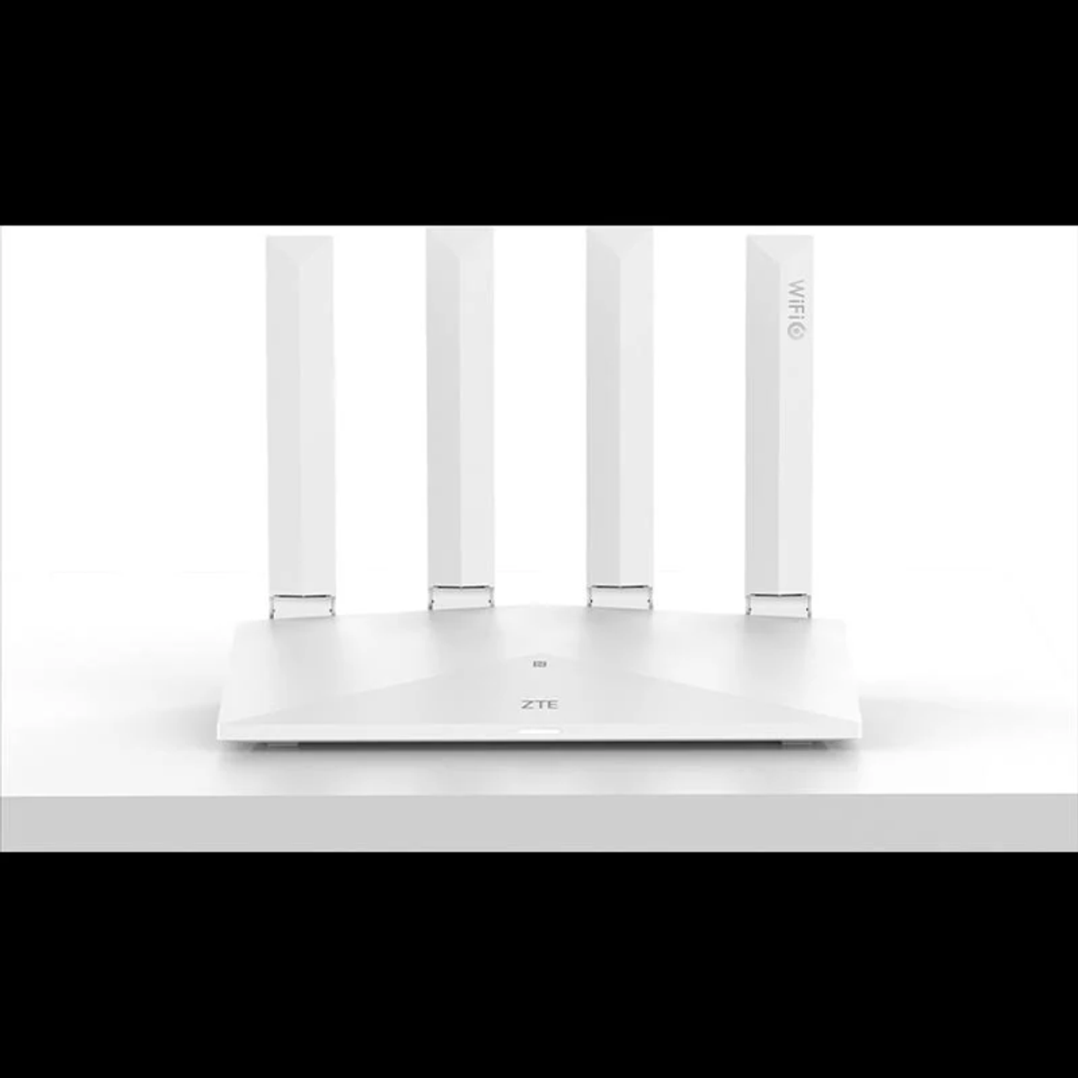Biały router z czterema antenami. Router znajduje się na białej powierzchni.