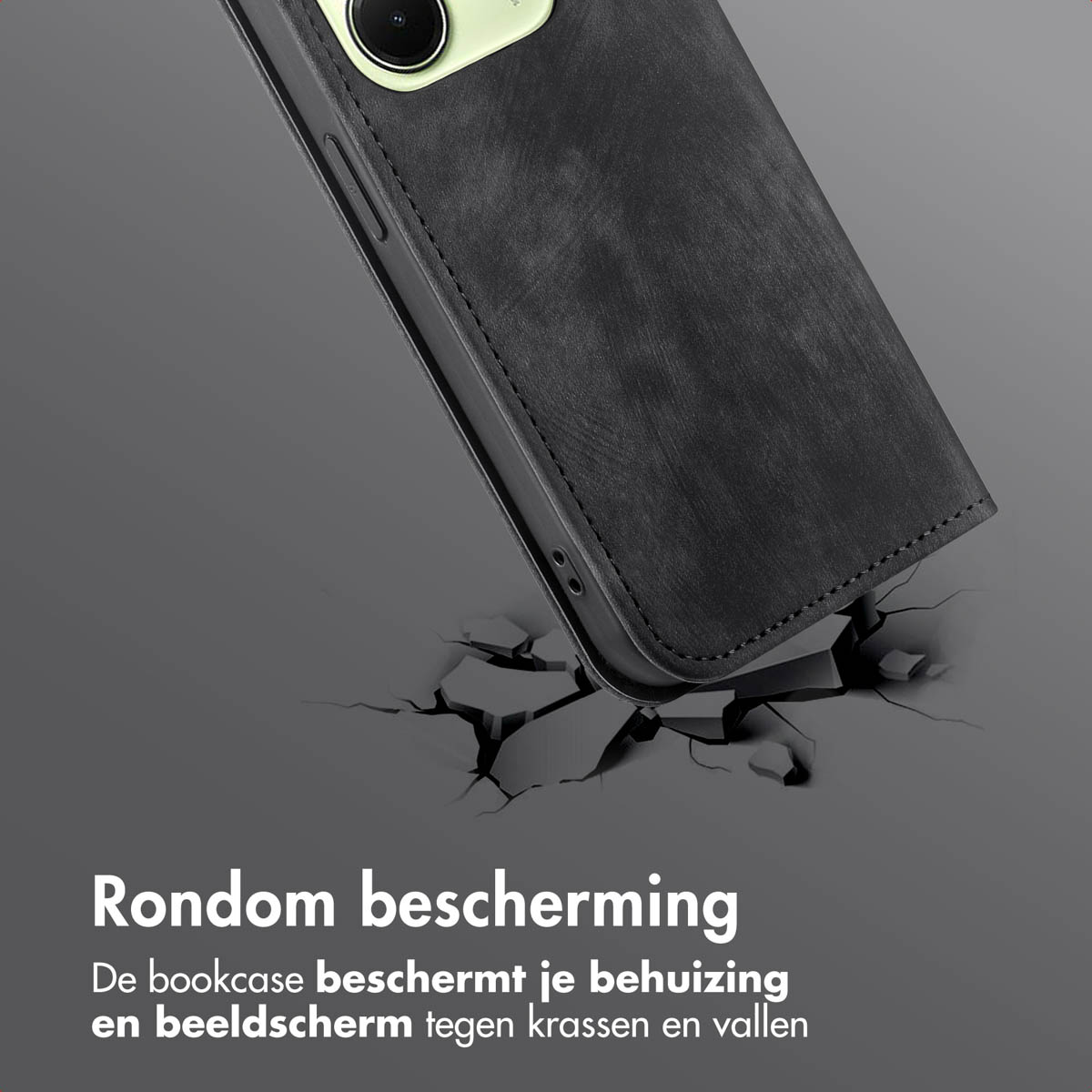 Zwart telefoonhoesje met een telefoon erin. Het telefoonhoesje is op de grond gebarsten, grijze achtergrond.