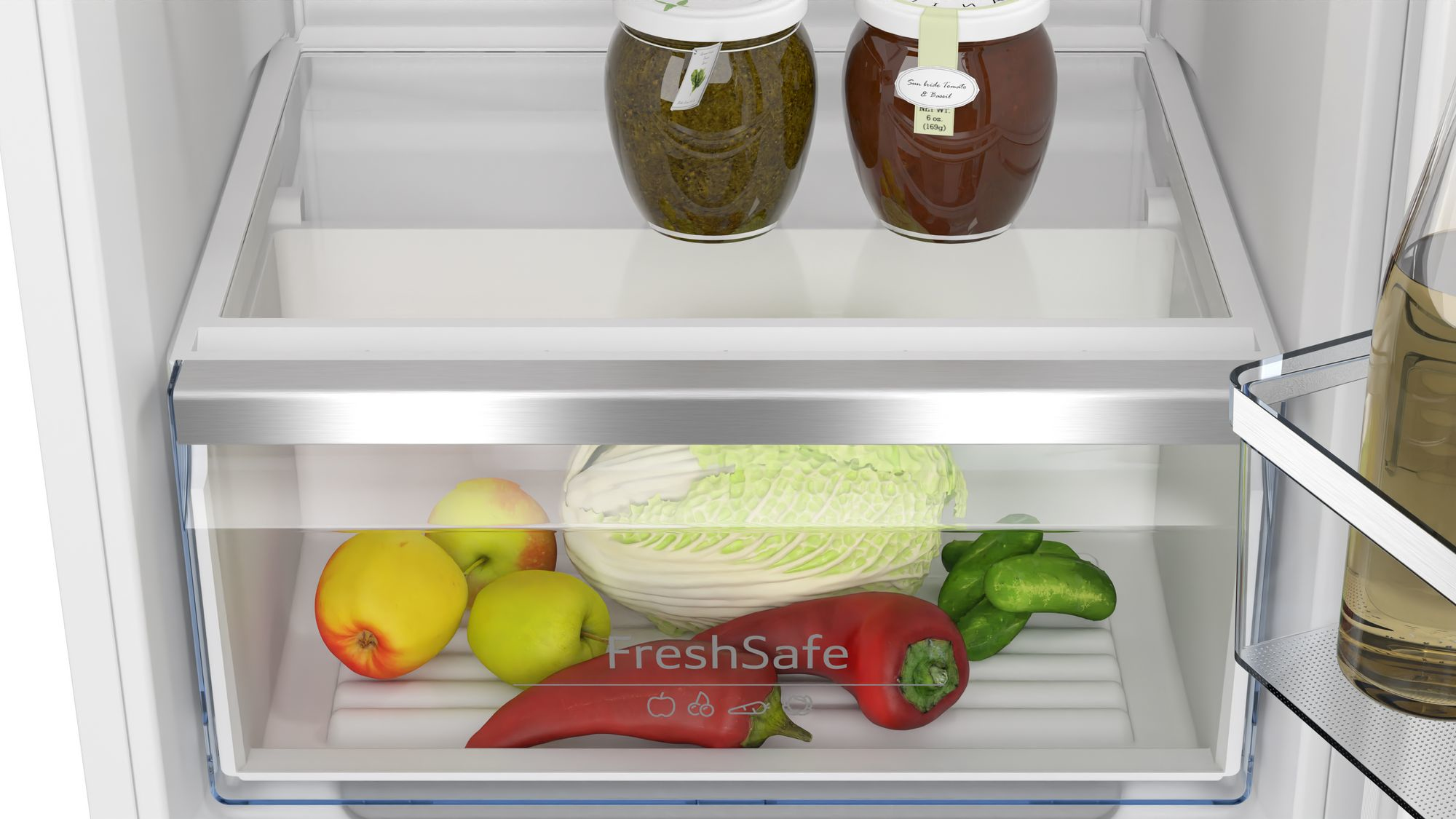 Nahaufnahme des Kühlschrankinneren mit Produkten. Gläser, Äpfel, Paprika und Kohl sind sichtbar.