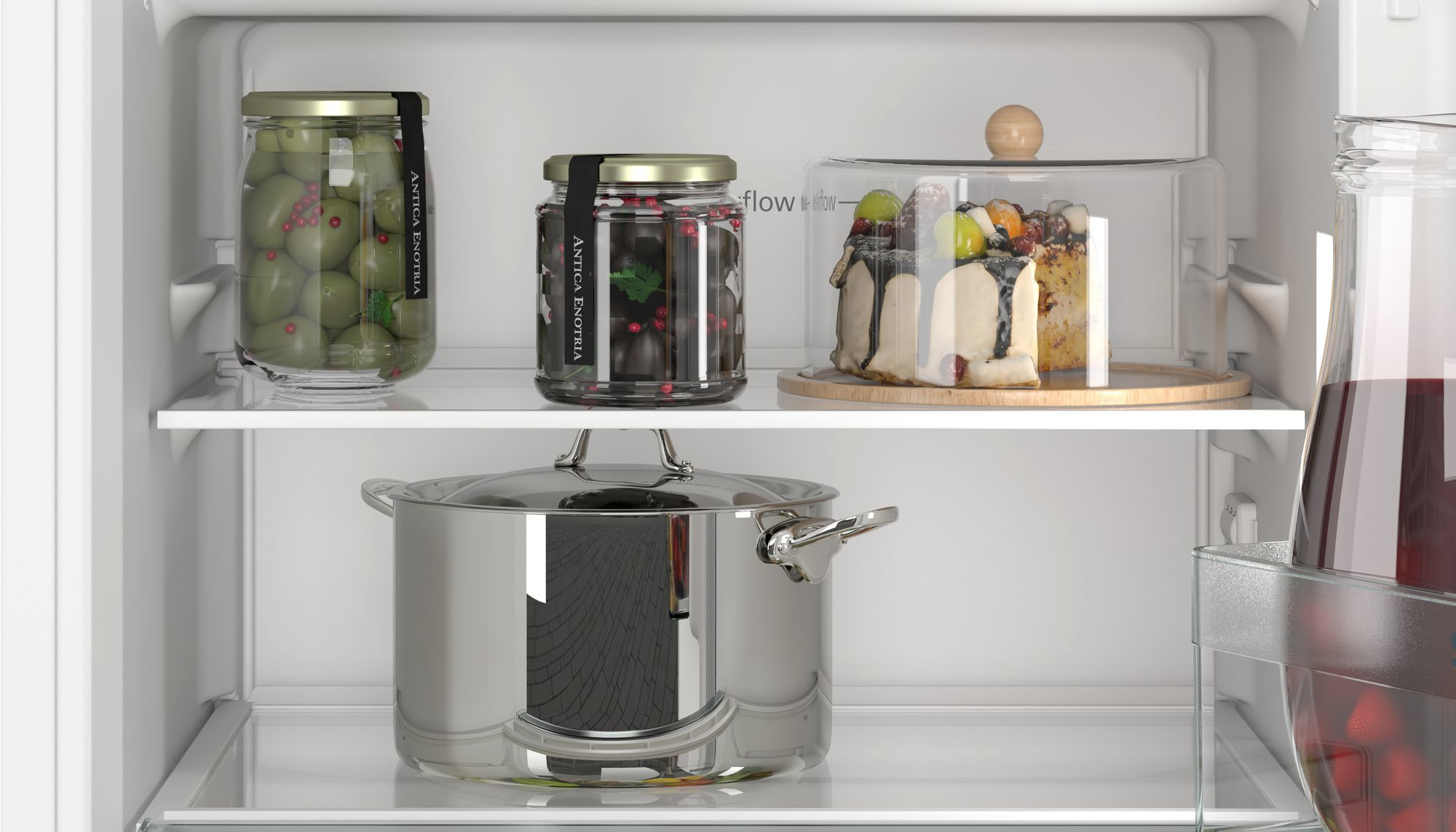 Kühlschrank-Innenraum mit Oliven, Kuchen und Topf. Lebensmittel auf Regalen. Sauber, gut beleuchtet.