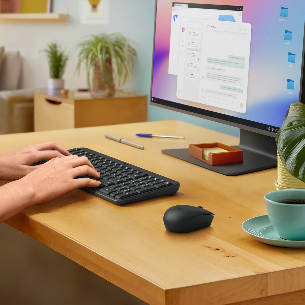 Mani che digitano su una tastiera nera con un mouse e una tazza di caffè sulla scrivania.