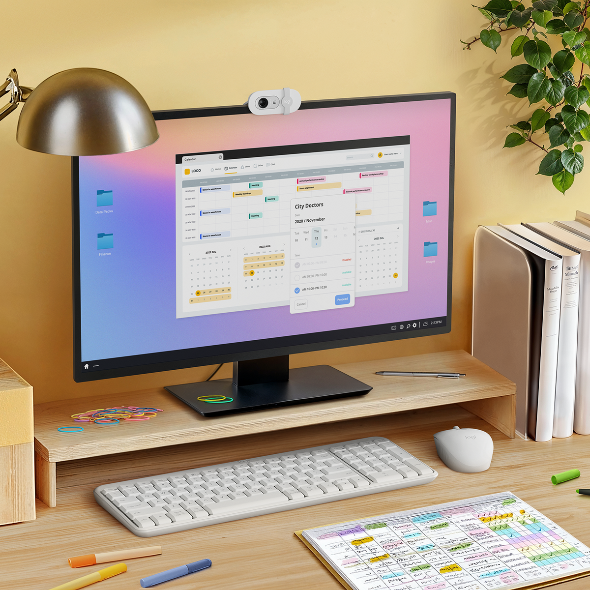 Configurazione desktop, monitor con calendario, tastiera, mouse, lampada da scrivania e note.