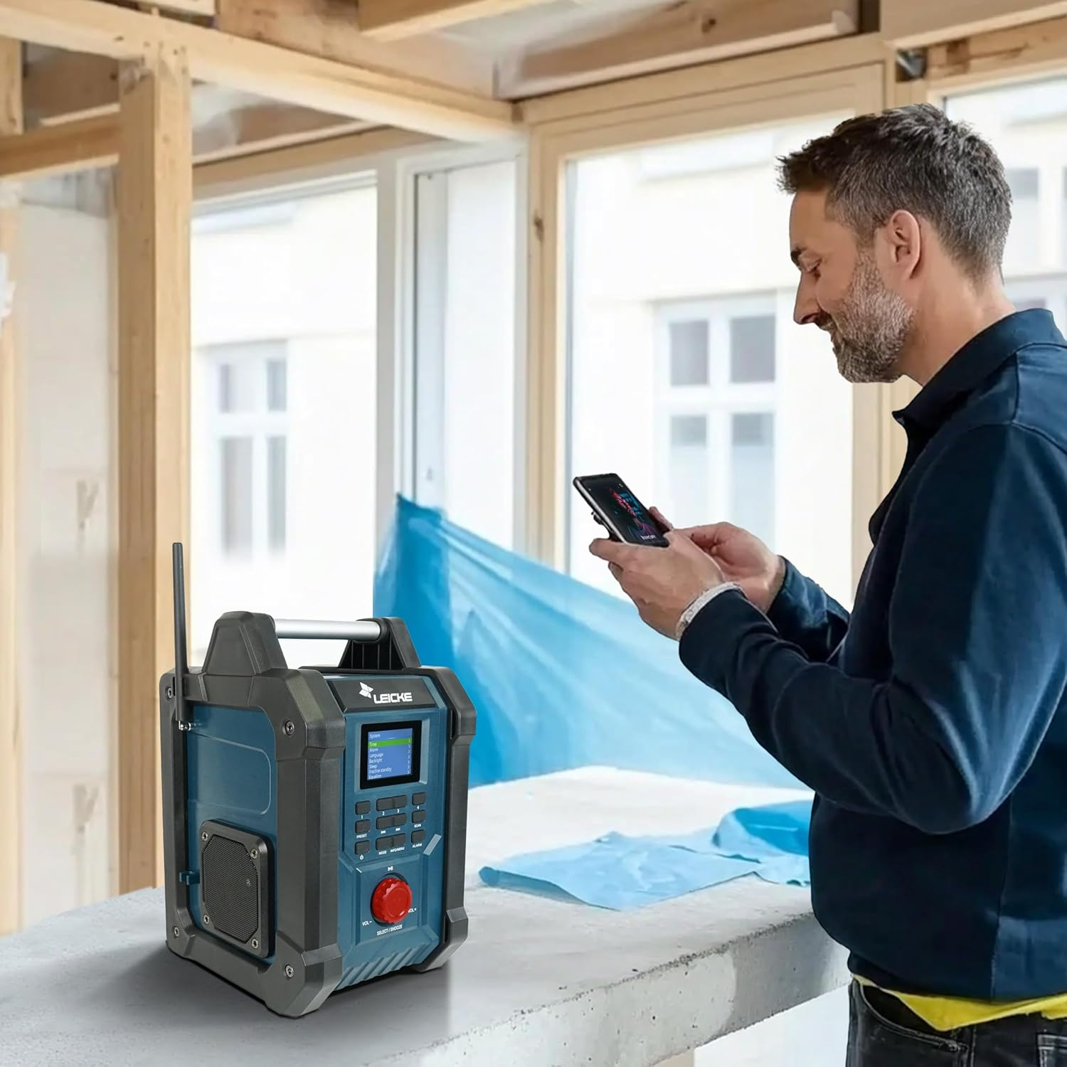 Uomo in una stanza con radio, che guarda il telefono. Struttura in legno sullo sfondo.