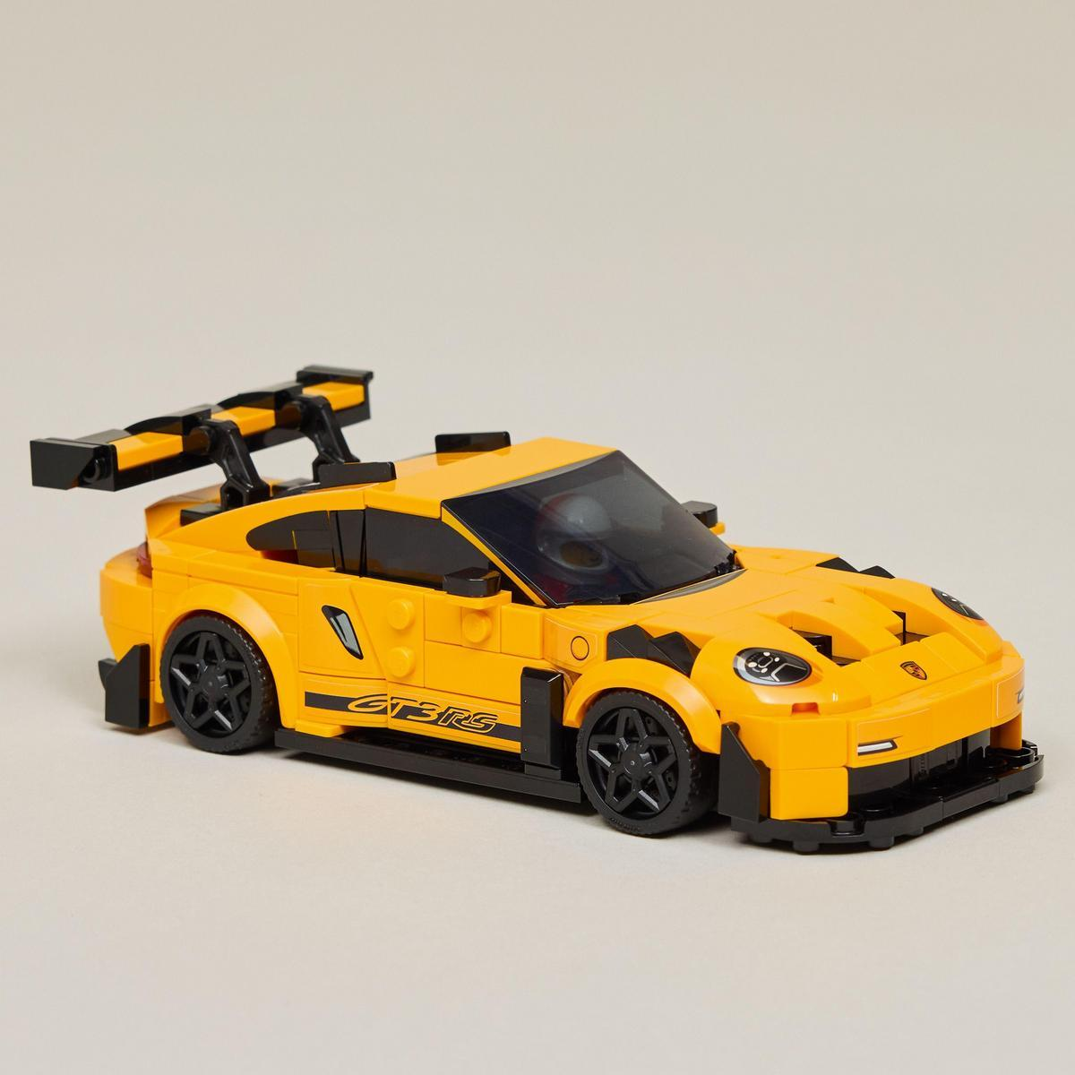 Żółty model samochodu Lego Porsche GT3 RS z czarnymi akcentami na jasnoszarym tle.