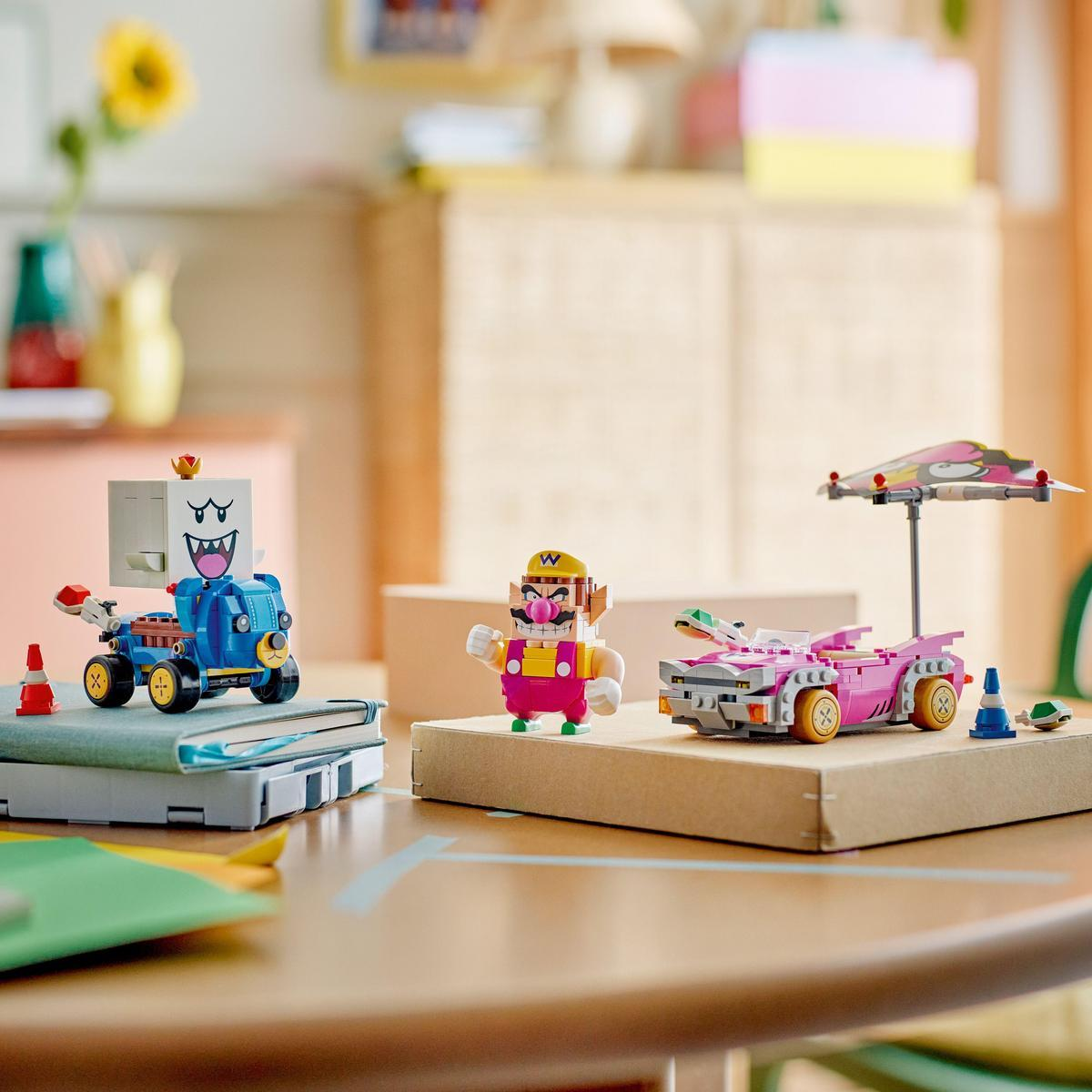 Zestaw Lego z postaciami z Mario, w tym Wario i niebieskim samochodem, na drewnianym stole.