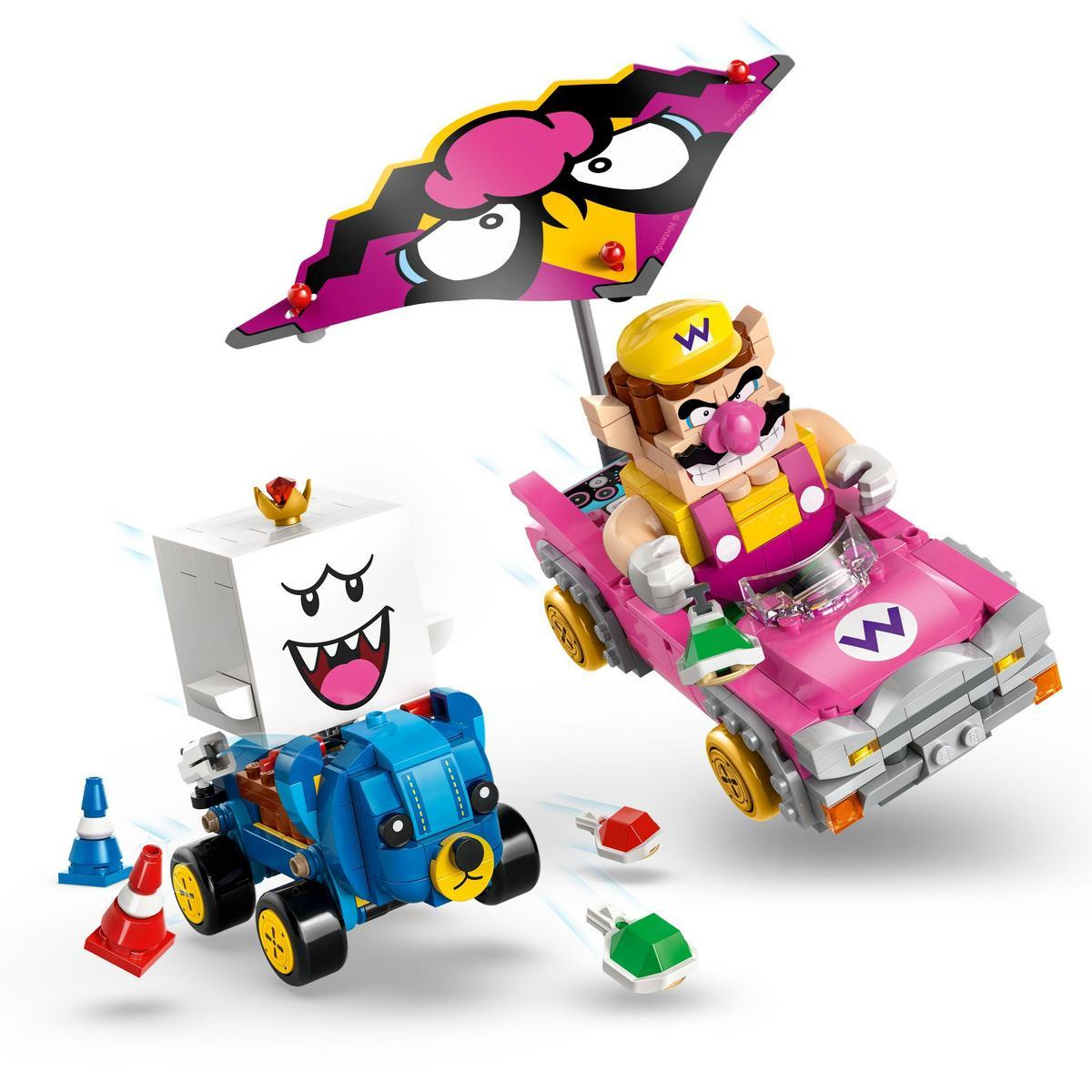 Postacie Lego Mario ścigają się. Wario w różowym samochodzie z parasolem. Boo w niebieskim. Monety.
