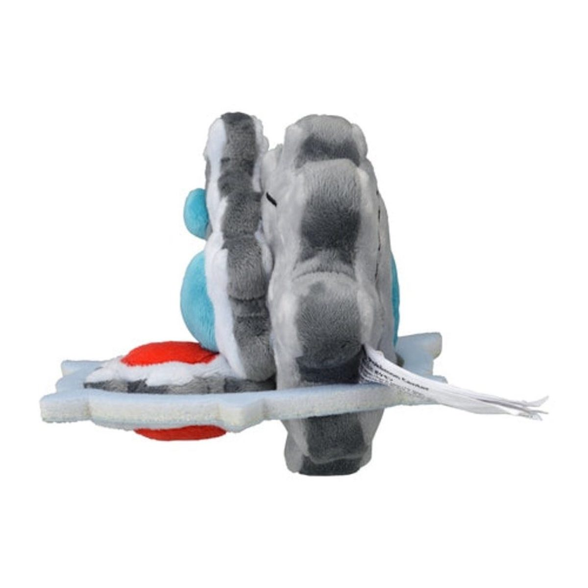 Ein Plüschtier eines Pokémon, grau, blau und rot. Es sitzt auf einer weißen Basis.
