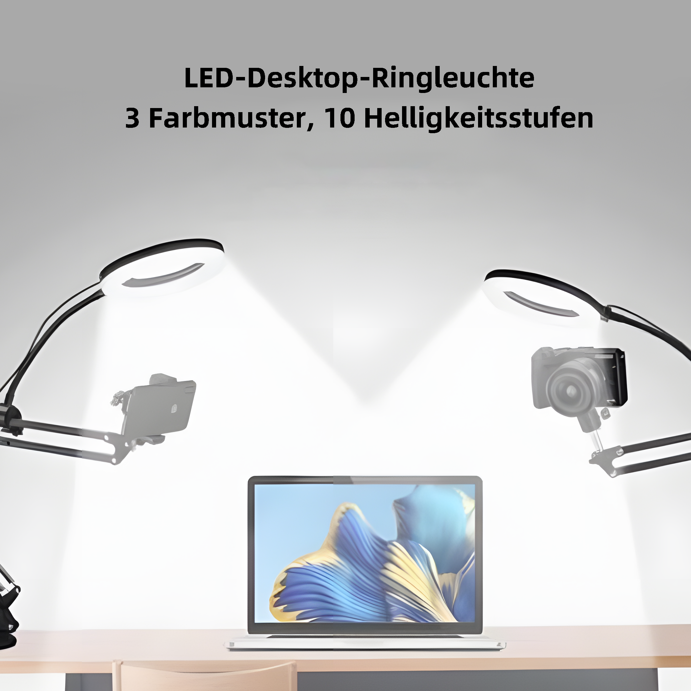 Zwei Ringlichter auf Ständern beleuchten Laptop und Telefon auf einem Schreibtisch.