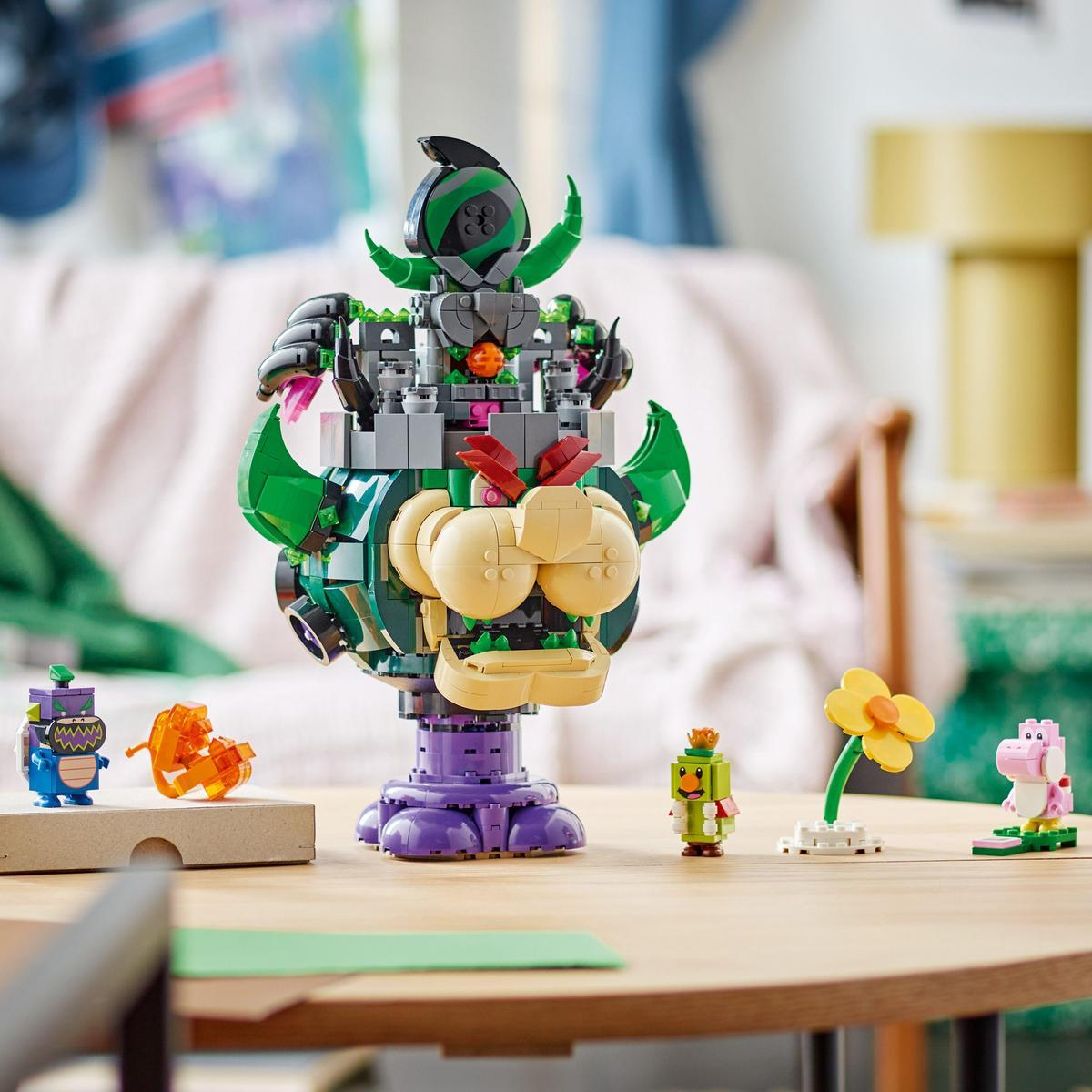 Set Lego con una struttura simile a Bowser, diverse figure Lego e un tavolo di legno.