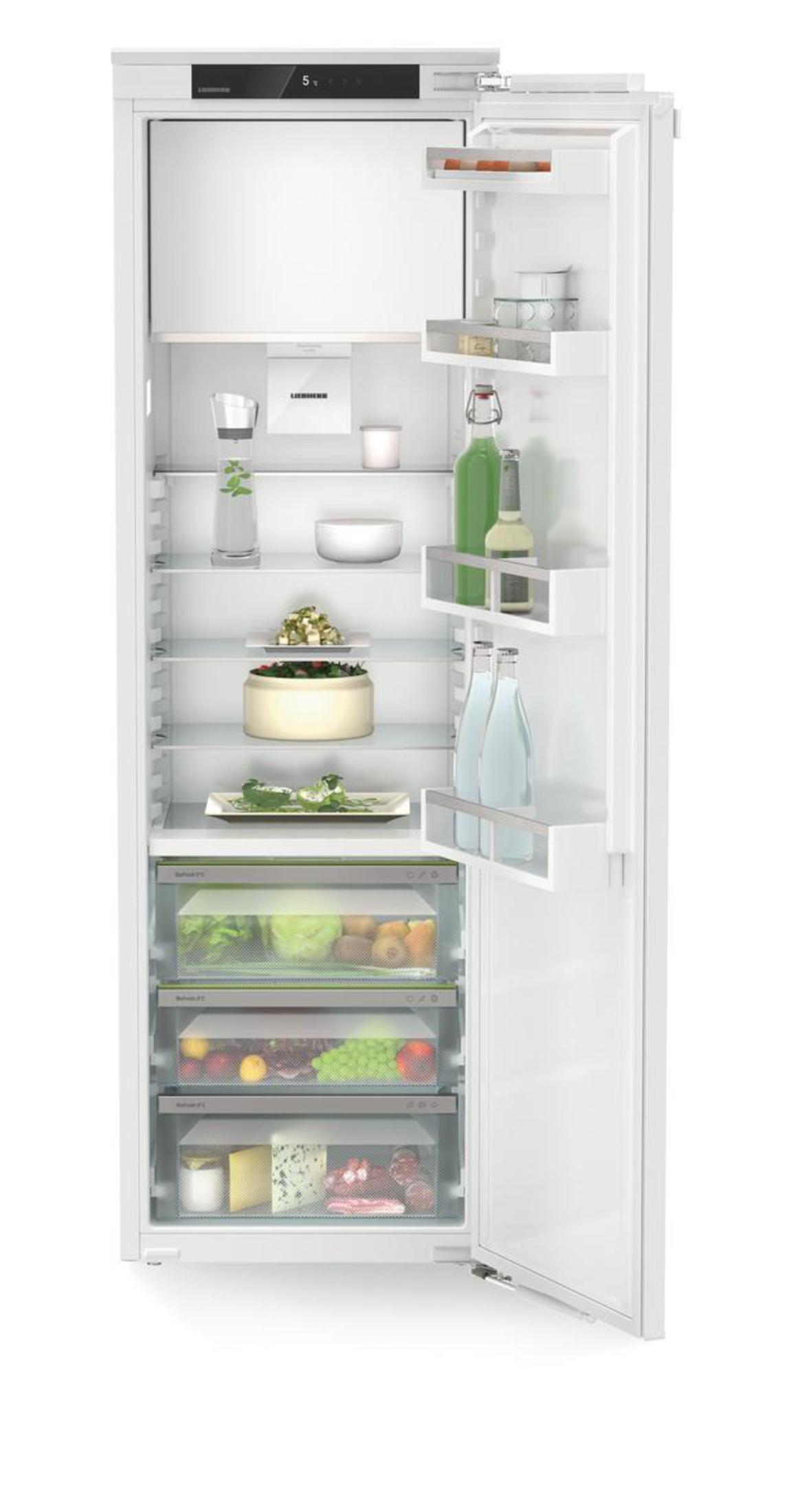 Interno di un frigorifero bianco con ripiani, alimenti e sezioni di stoccaggio regolabili.