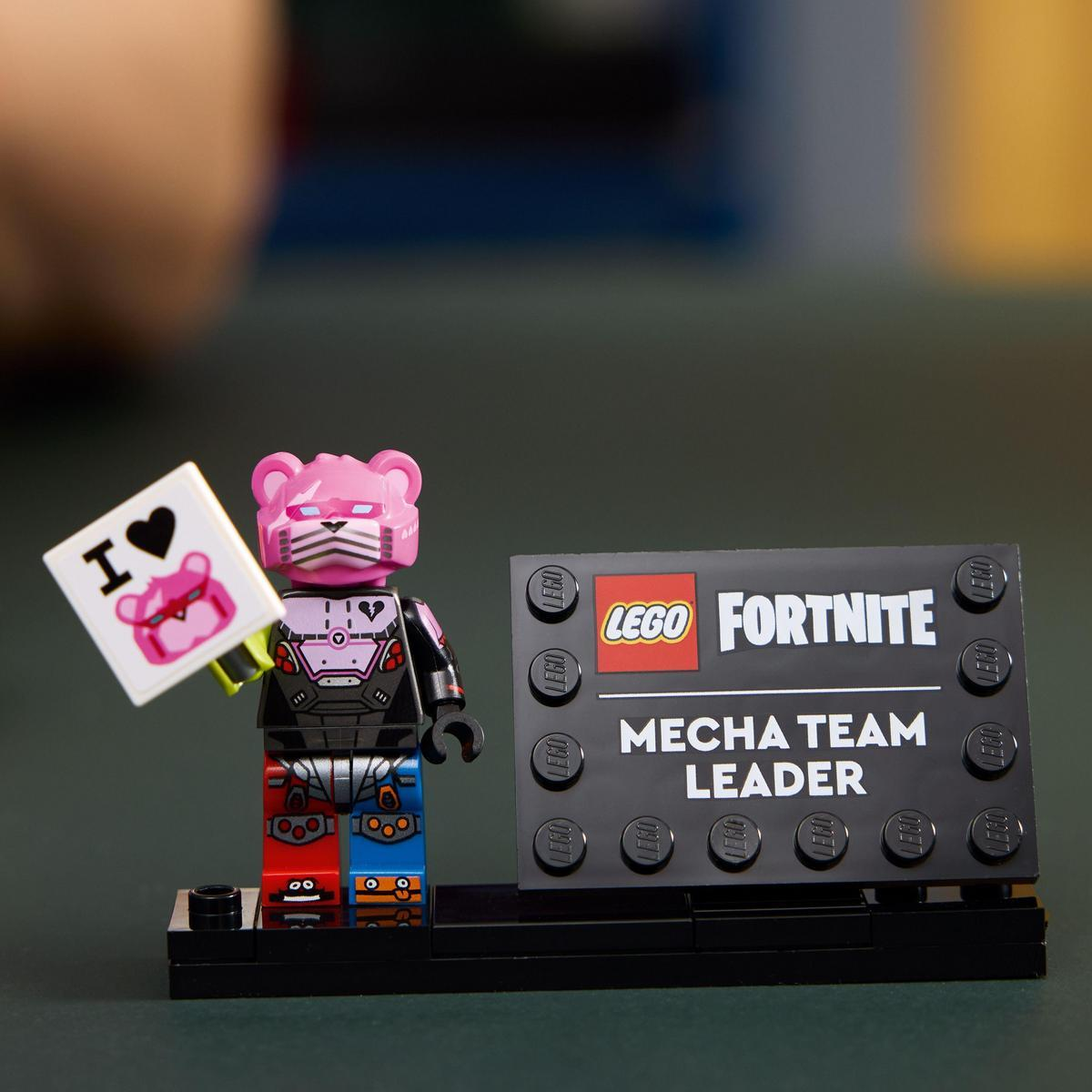 Figurka Lego Fortnite trzymająca znak serca i znak z napisem Mecha Team Leader.