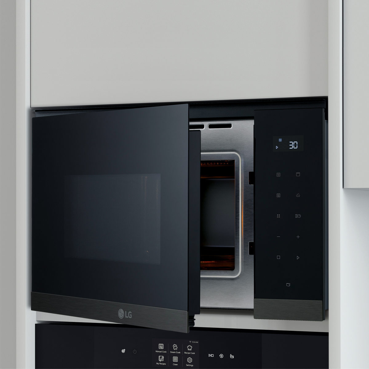Otwarta czarna kuchenka mikrofalowa LG. Widoczne wnętrze, szklany talerz i metalowy stojak.