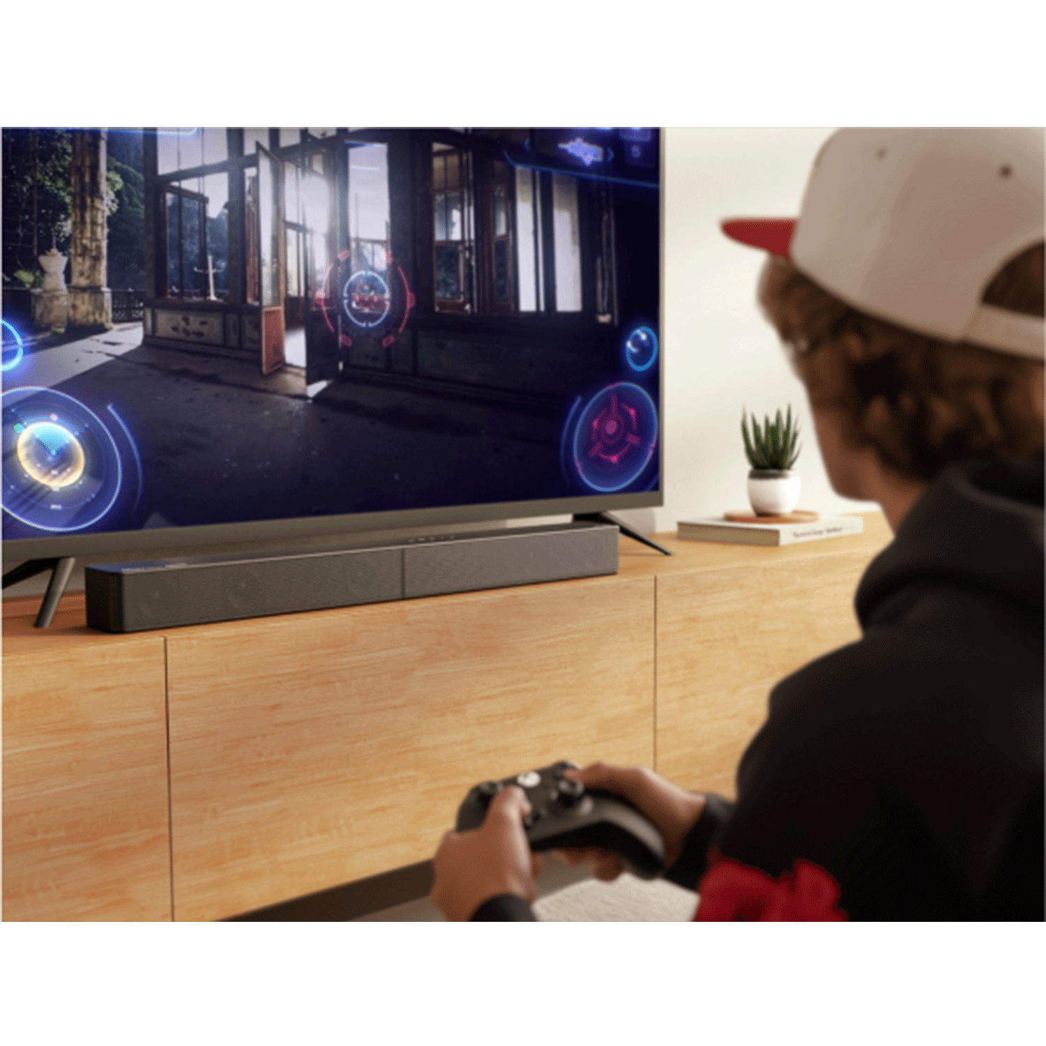 Giocatore con controller, soundbar sotto la TV.