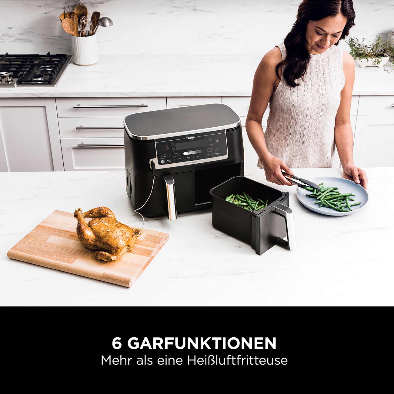 Frytkownica powietrzna stoi na blacie z kurczakiem i warzywami.