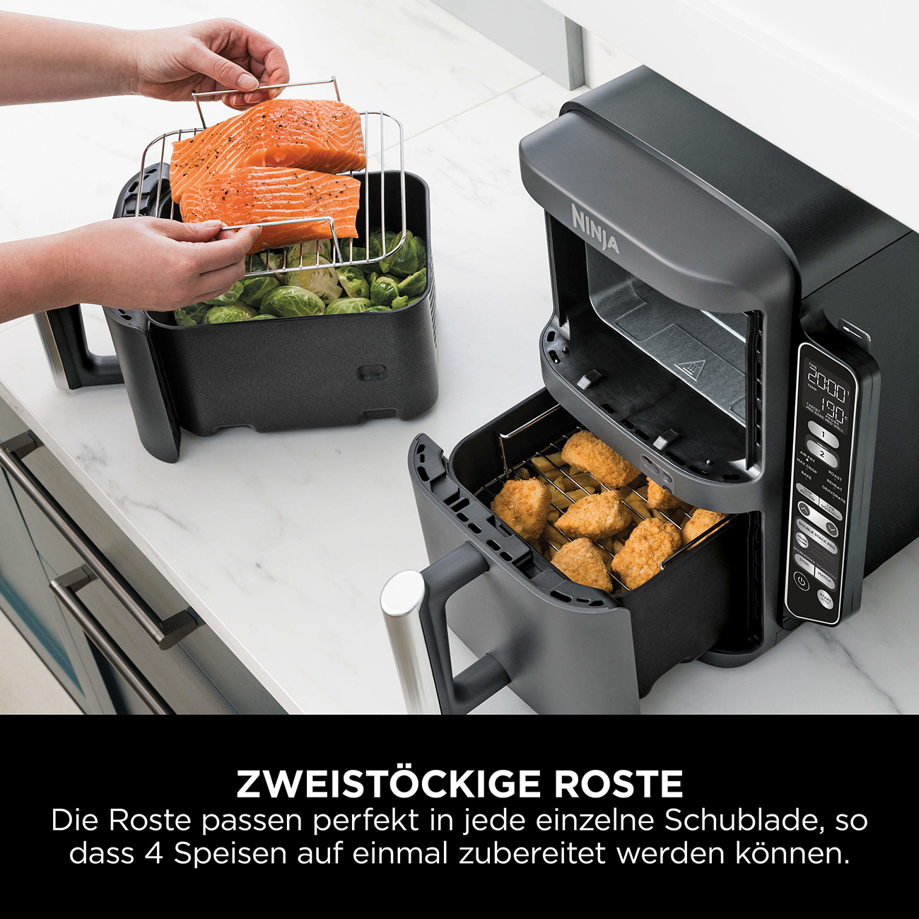 Czarna frytkownica beztłuszczowa Ninja z jedzeniem w środku. Osoba trzyma tacę z łososiem do włożenia do frytkownicy.