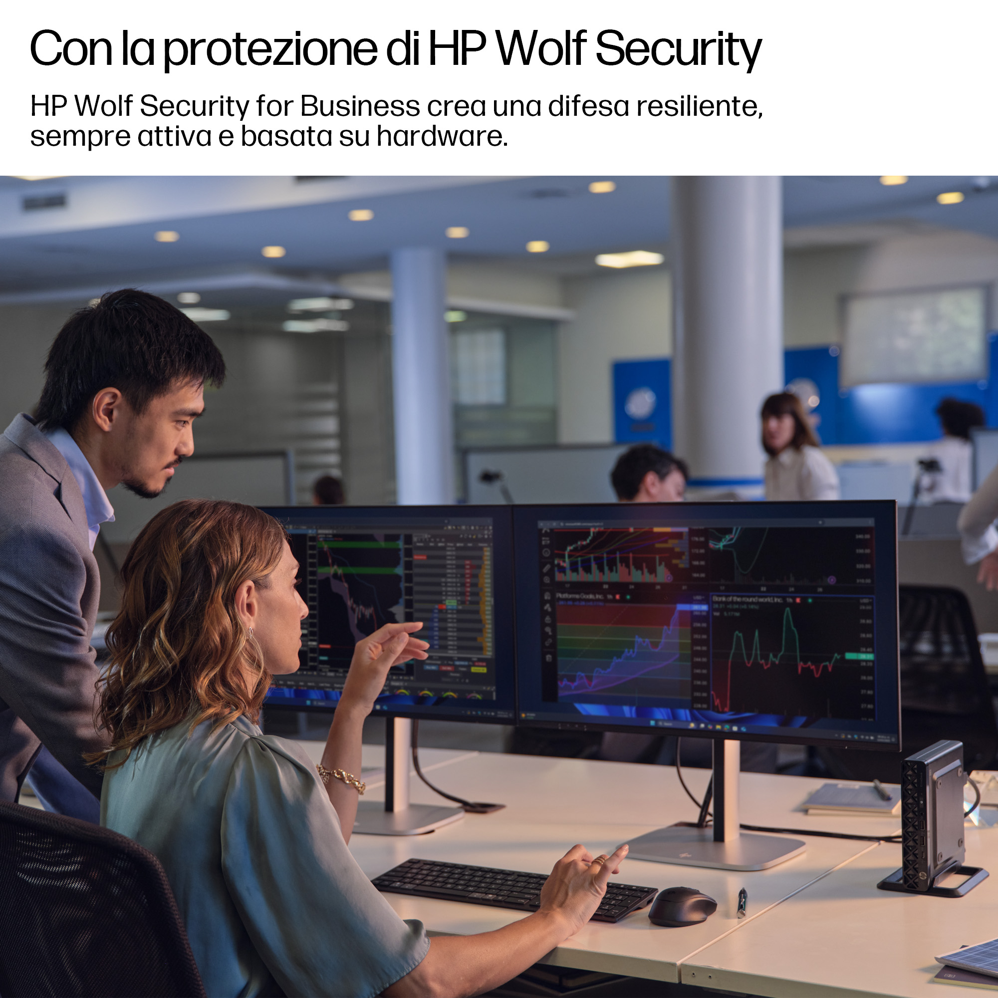 Due persone che guardano due schermi di computer. Gli schermi mostrano grafici e dati.