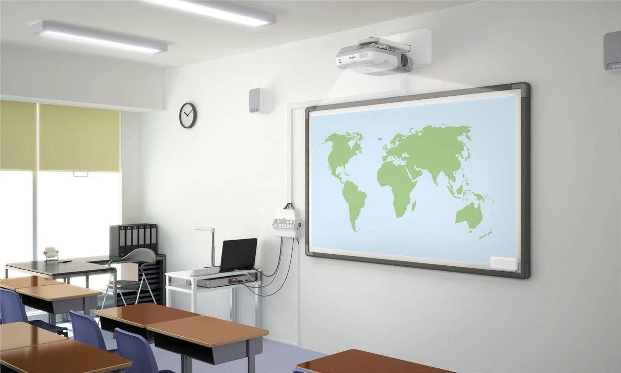 Classroom with a world map on the board, a projector, speakers, desks, and a laptop.