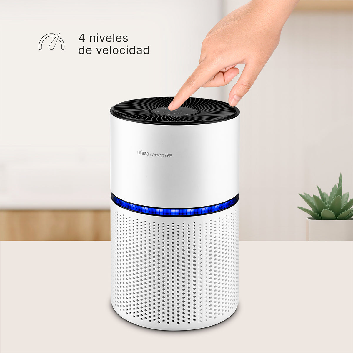 Mano tocando la parte superior de un purificador de aire blanco. Se indican 4 niveles de velocidad.