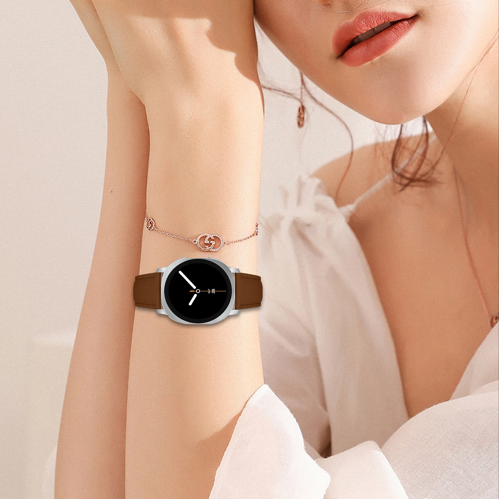 Frau trägt eine Smartwatch mit schwarzem Bildschirm und braunem Lederarmband. Die Uhrzeit wird angezeigt.