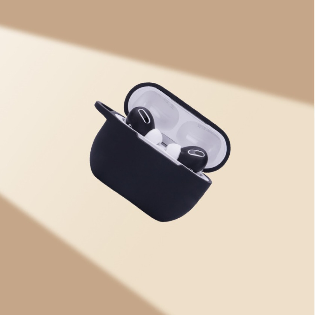 Auriculares negros en un estuche negro, flotando sobre un fondo beige, con luz suave.