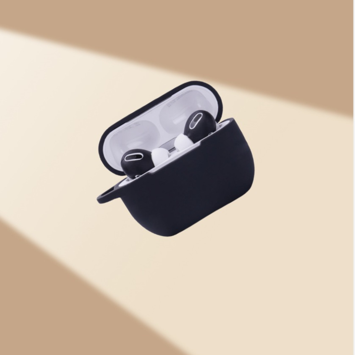 Funda AirPod negra con tapa abierta, auriculares negros dentro. Fondo beige con sombra.