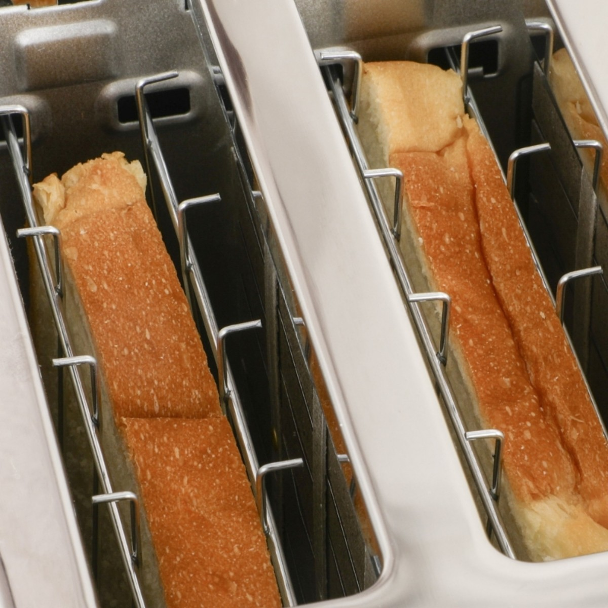 Nahaufnahme eines Toasters mit Toastscheiben im Inneren. Der Toast ist goldbraun und verzehrfertig.