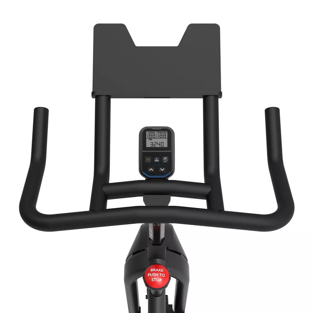 Panel sterowania i kierownica roweru stacjonarnego. Wyświetlacz cyfrowy pokazujący dane, czerwony przycisk stop.