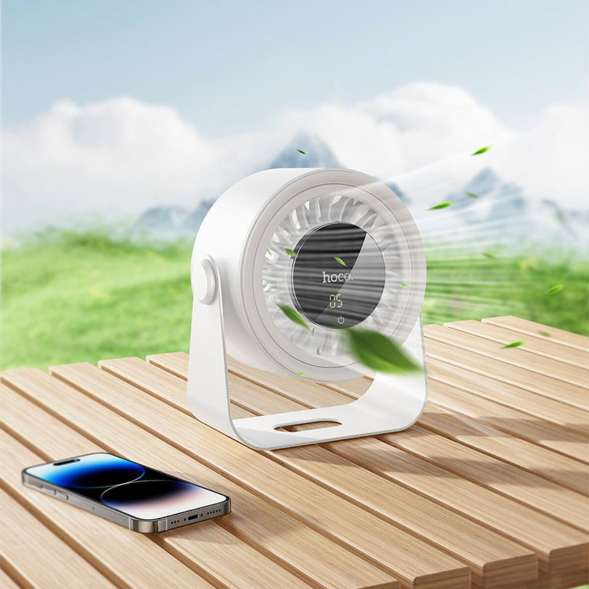Un purificador de aire blanco se encuentra sobre una mesa de madera con un teléfono, contra un fondo verde borroso.