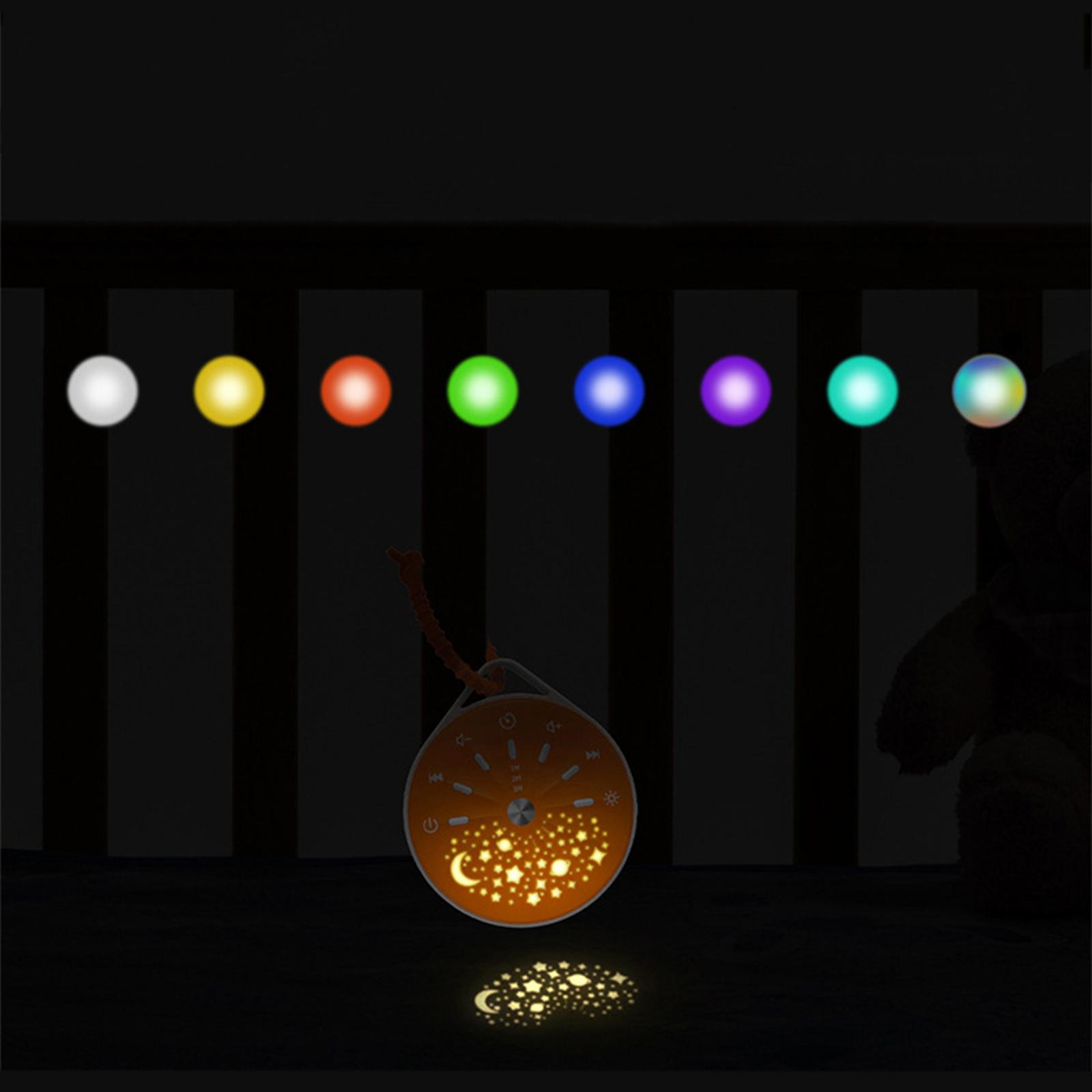 Soundmaschine mit Sternen auf dem Kinderbett, farbige Lichter darüber.