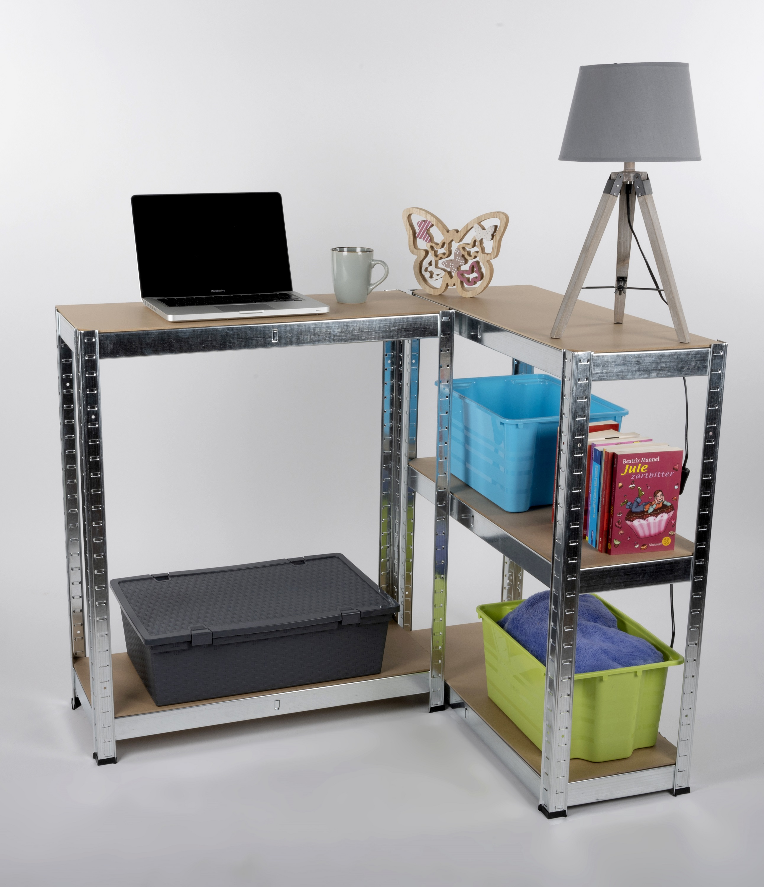 Een bureau gemaakt van metalen schappen met een laptop, lamp en accessoires, tegen een witte achtergrond.