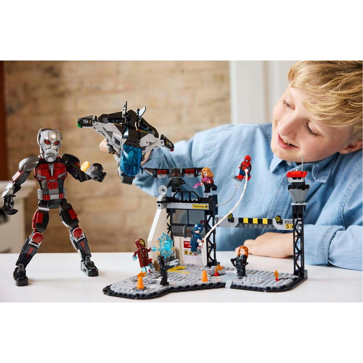 Dziecko bawi się zestawem LEGO Marvel. Ant-Man i inne postacie Marvela są w scenie.